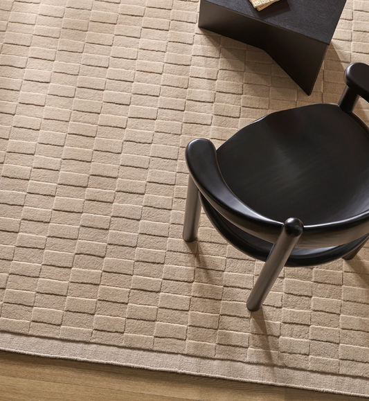 A handcrafted wool rug featuring a sculptural checkerboard design, bringing depth, texture, and bold sophistication to contemporary interiors.