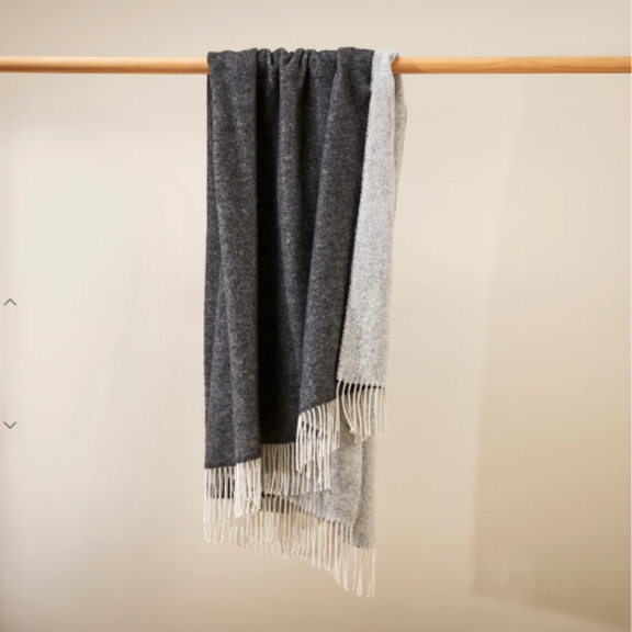Soft, reversible merino wool Casa Throw draped on sofa