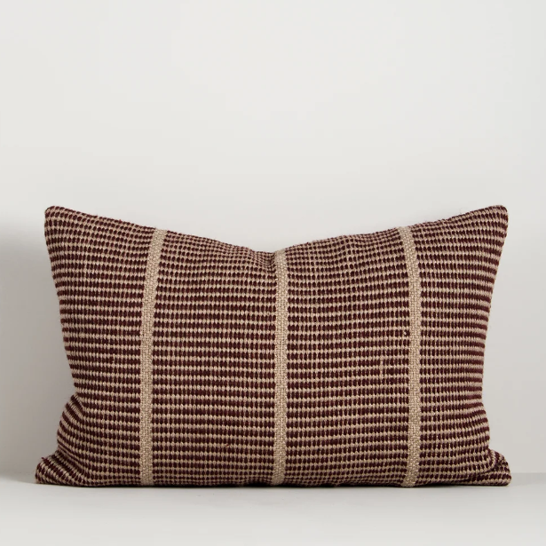 Shop the Baya Shore Outdoor Cushion at Comber and Comber. A handwoven recycled PET lumbar cushion with a timeless linear design, available in multiple colours.