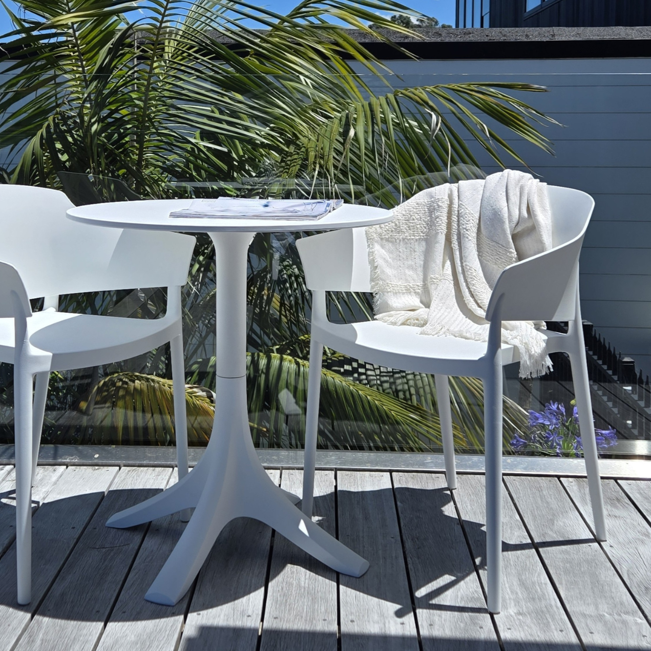 Outdoor table in white styled with plastic outdoor chairs