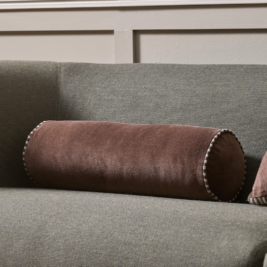 Cylindrical Elliot Bolster styled on a contemporary sofa