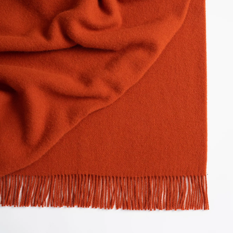 Shop the Nevis lambswool throw 130x200cm – made from 100% New Zealand wool with a soft, thick texture and tassel fringe, perfect for cosy living and gifting.