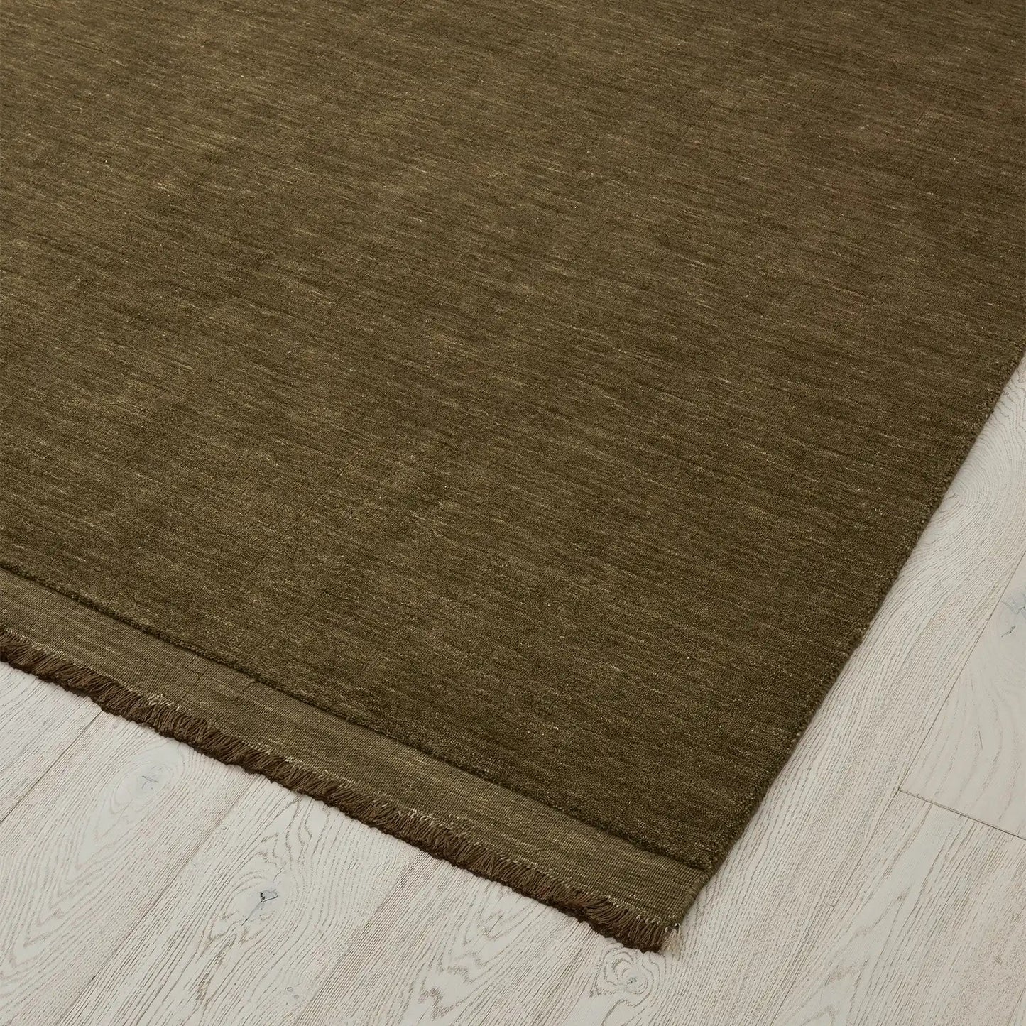 Deep olive rug on a light wood floor. 2x3m 3x4m. 100% NZ wool