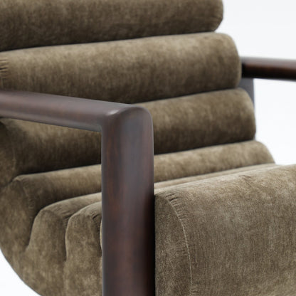 A bold, sculptural accent chair with channelled velvet upholstery and distinctive timber arms.
