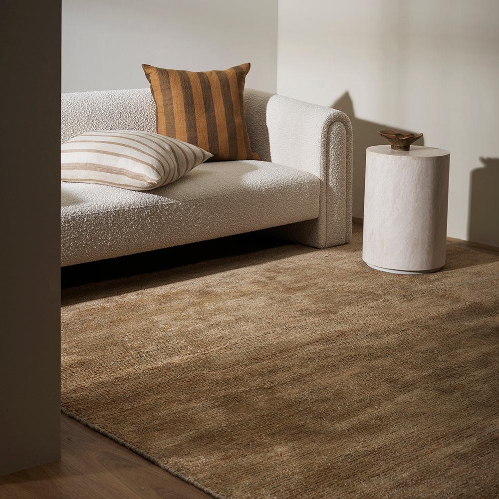 Natural-toned Anchorage rug anchoring furniture in interior space – BLACK Concept Store