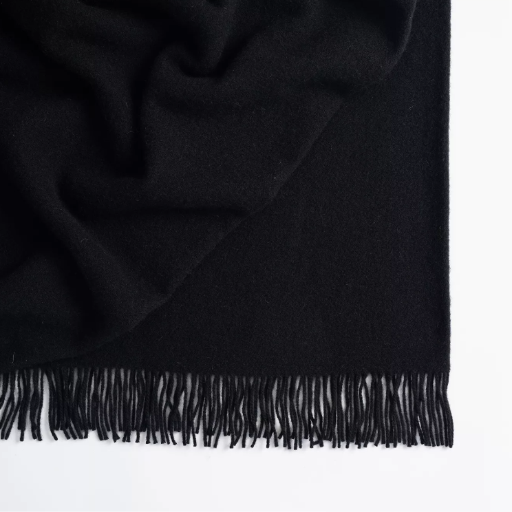 Shop the Nevis lambswool throw 130x200cm – made from 100% New Zealand wool with a soft, thick texture and tassel fringe, perfect for cosy living and gifting.