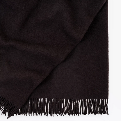 Shop the Nevis lambswool throw 130x200cm – made from 100% New Zealand wool with a soft, thick texture and tassel fringe, perfect for cosy living and gifting.