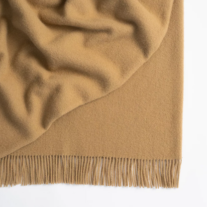 Shop the Nevis lambswool throw 130x200cm – made from 100% New Zealand wool with a soft, thick texture and tassel fringe, perfect for cosy living and gifting.