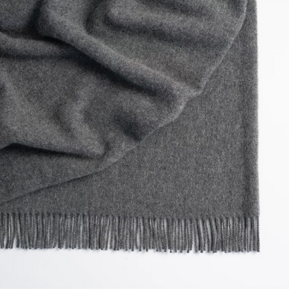 Shop the Nevis lambswool throw 130x200cm – made from 100% New Zealand wool with a soft, thick texture and tassel fringe, perfect for cosy living and gifting.