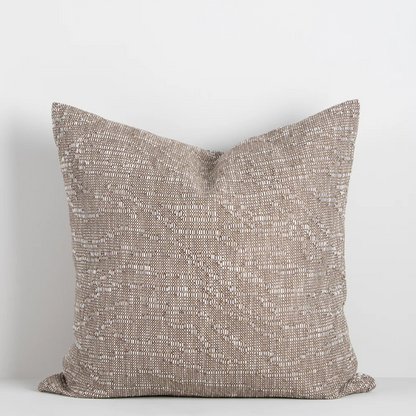 The Adler 55x55cm cushion features a subtle flecked weave in warm tones, adding refined texture and versatility to your interior styling.