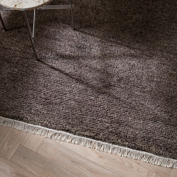 Brown textured rug with a wooden bench and coffee cup on a wooden floor. 100% NZ Wool