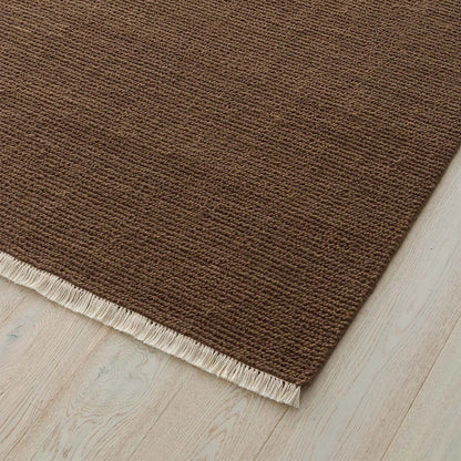 Rich clay toned rug with a textured pattern and fringe on a wooden floor. 2x3 3x4. 100% NZ wool