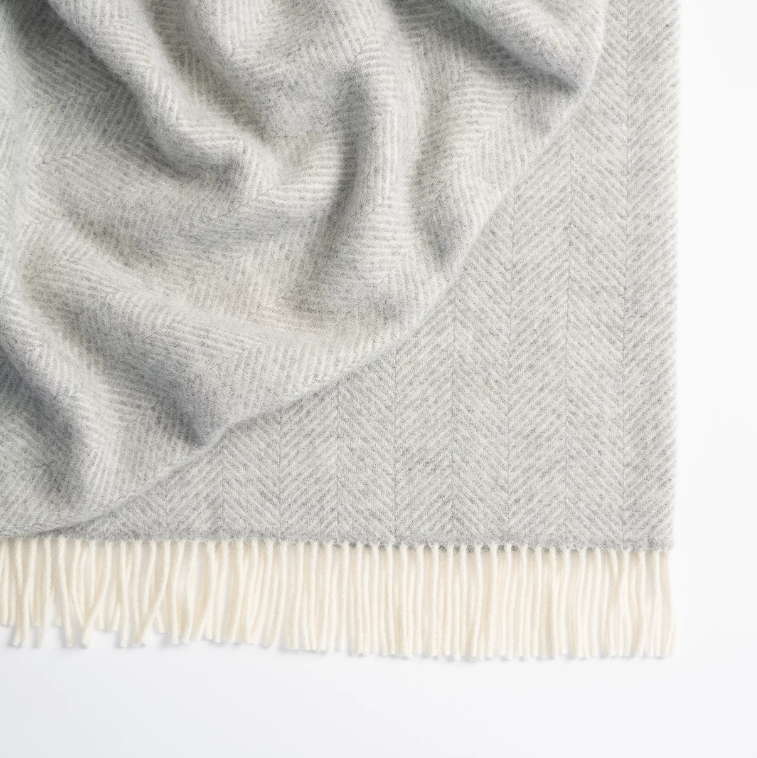 Shop the Magnus wool throw 150x183cm – a thick, 100% New Zealand wool throw with classic herringbone weave and fringe, perfect for cosy living and gifting.