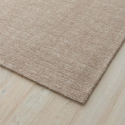 light brown textured rug on a wooden floor. 2x3. 100% nz Wool