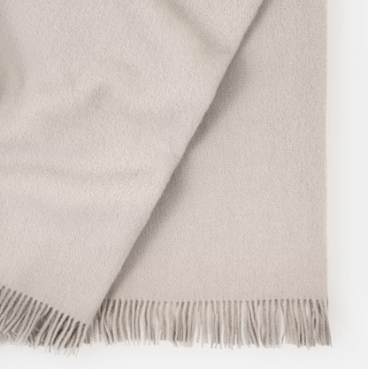 Shop the Nevis lambswool throw 130x200cm – made from 100% New Zealand wool with a soft, thick texture and tassel fringe, perfect for cosy living and gifting.