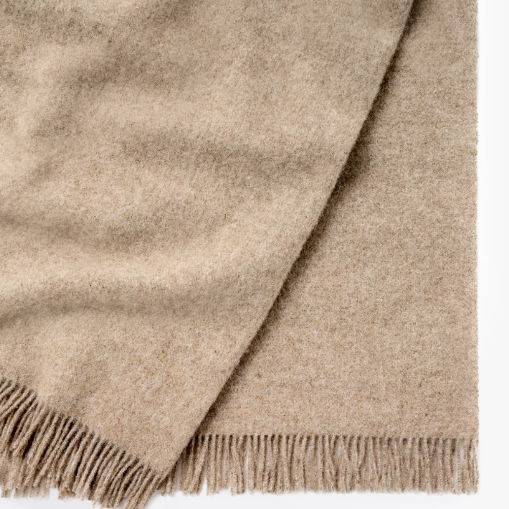 Shop the Nevis lambswool throw 130x200cm – made from 100% New Zealand wool with a soft, thick texture and tassel fringe, perfect for cosy living and gifting.