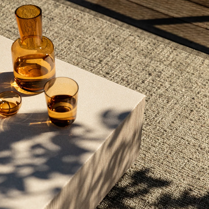 Shop the Baya Ormond Outdoor Rug at Comber and Comber. A handwoven recycled PET rug with a soft bouclé texture. Available in Biscotti and Mineral.