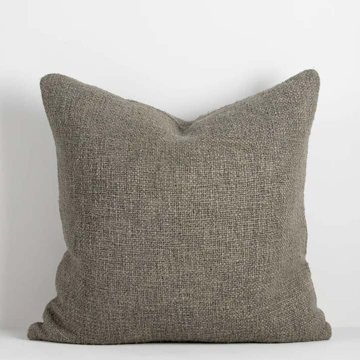 Shop the Cyprian cushion – handwoven from cotton, linen, and viscose with a chunky artisan texture, perfect for layering or statement styling.