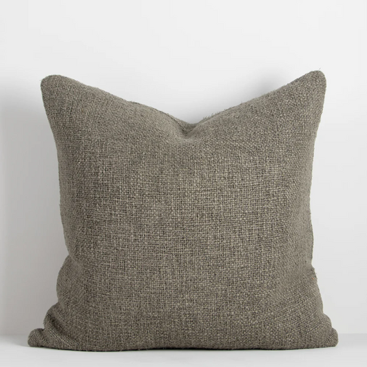 Shop the Cyprian cushion – handwoven from cotton, linen, and viscose with a chunky artisan texture, perfect for layering or statement styling.