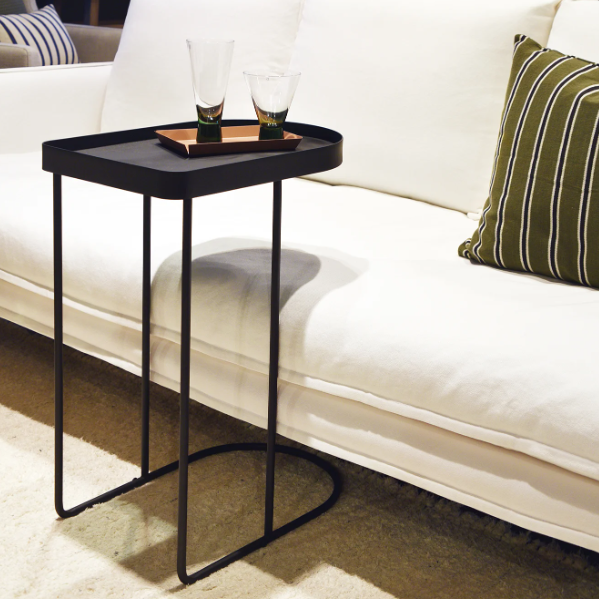 Minimalist matte black metal side table in modern interior