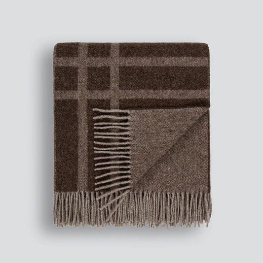 A timeless wool throw with a refined plaid design, crafted from 100% New Zealand lambswool for warmth and comfort.