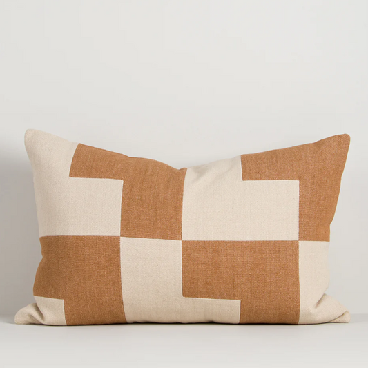 A striking geometric cushion in warm oat and caramel tones, designed to bring texture, pattern, and contemporary style to any interior.
