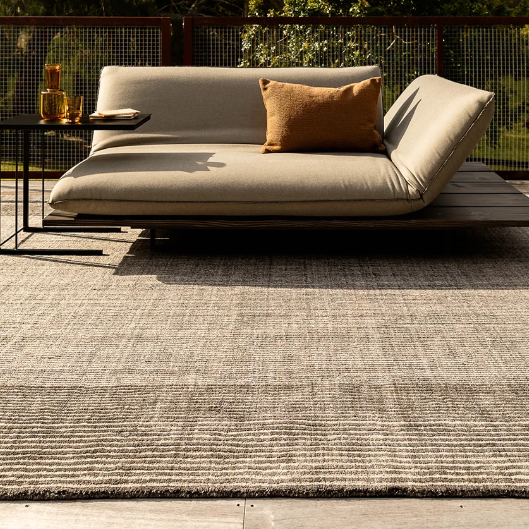 Shop the Baya Bedrock Outdoor Rug at Comber and Comber. A textured recycled PET rug for sheltered outdoor living. Available in Sand, Claret and Zinc.