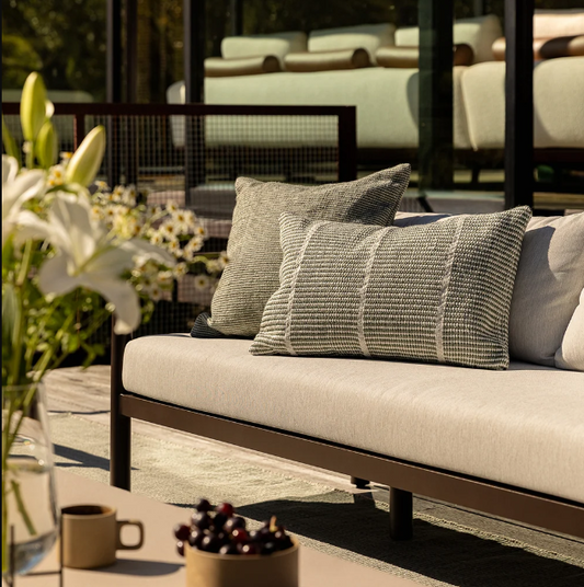 Shop the Baya Shore Outdoor Cushion at Comber and Comber. A handwoven recycled PET lumbar cushion with a timeless linear design, available in multiple colours.