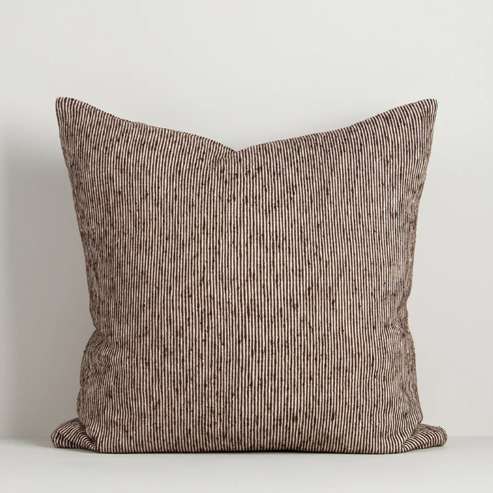 A beautifully textured cotton cushion featuring a subtle pinstripe weave and earthy colour palette, designed to bring warmth, depth, and effortless layering to contemporary interiors.