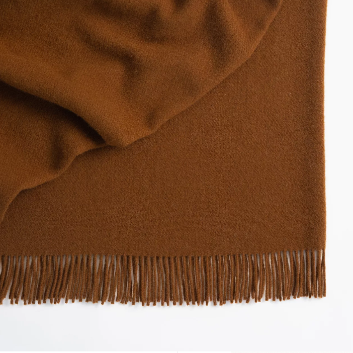 Shop the Nevis lambswool throw 130x200cm – made from 100% New Zealand wool with a soft, thick texture and tassel fringe, perfect for cosy living and gifting.
