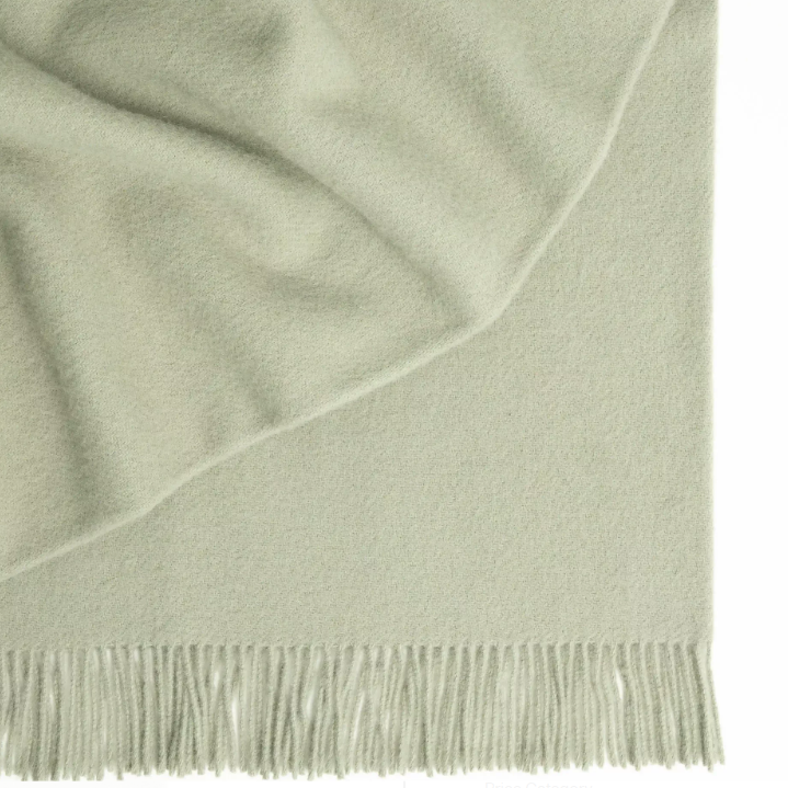 Shop the Nevis lambswool throw 130x200cm – made from 100% New Zealand wool with a soft, thick texture and tassel fringe, perfect for cosy living and gifting.