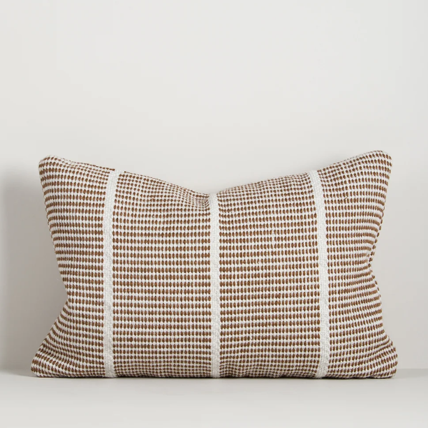 Shop the Baya Shore Outdoor Cushion at Comber and Comber. A handwoven recycled PET lumbar cushion with a timeless linear design, available in multiple colours.