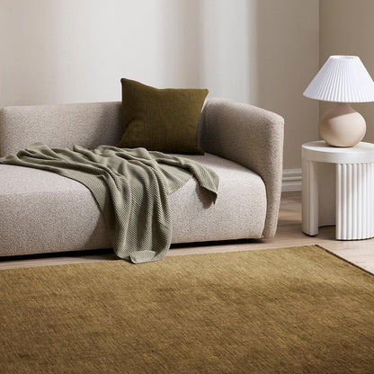 Handknotted moss green wool rug styled in modern living space – BLACK Concept Store