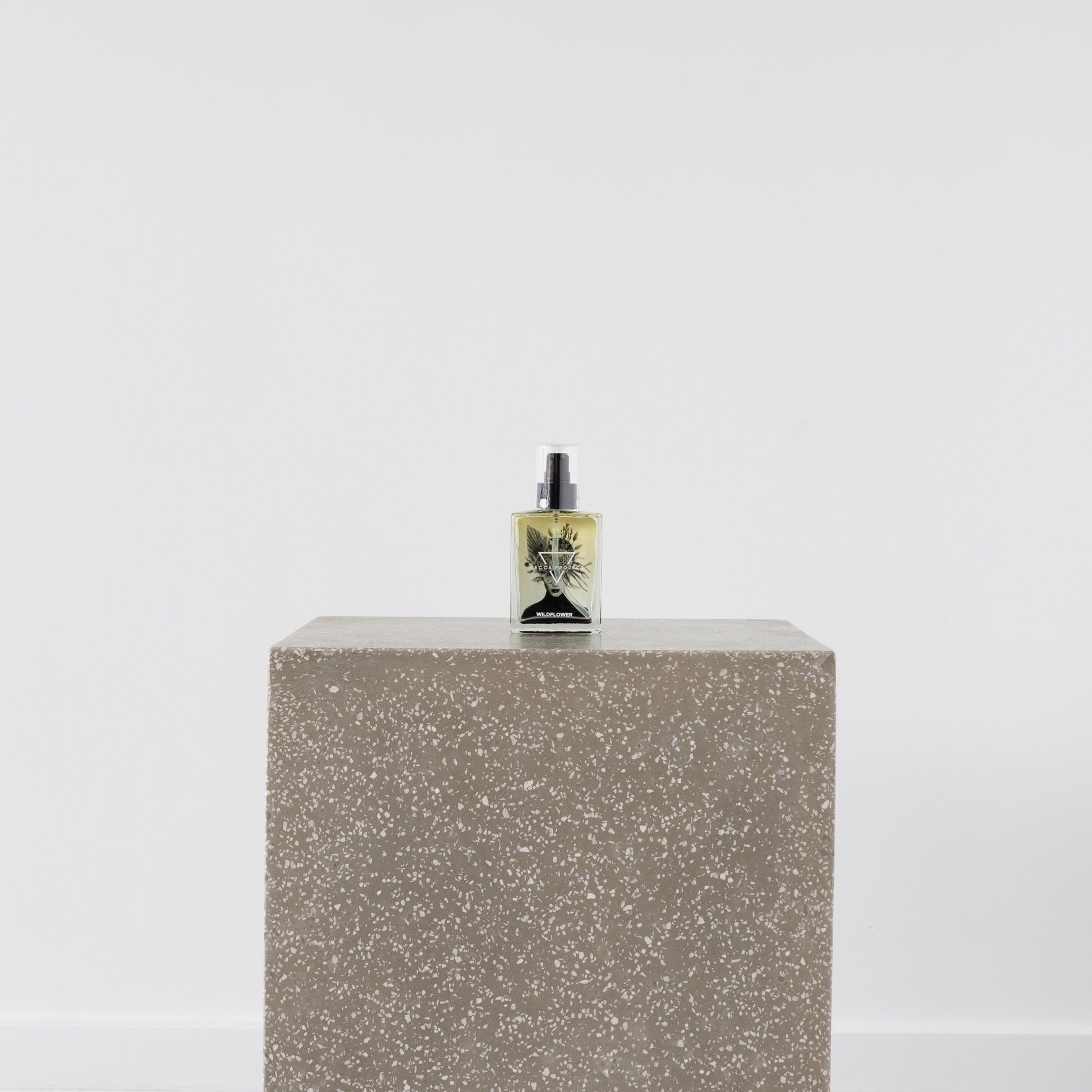 Becca Body Oil bottle on wooden surface with natural oils